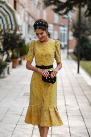 invitada perfecta con vestido de plumetti mostaza con botones y volante para bodas