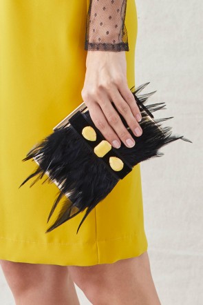 clutch de fiesta de laton dorado con plumas negras y piedras amarillas para invitadas de boda apparentia