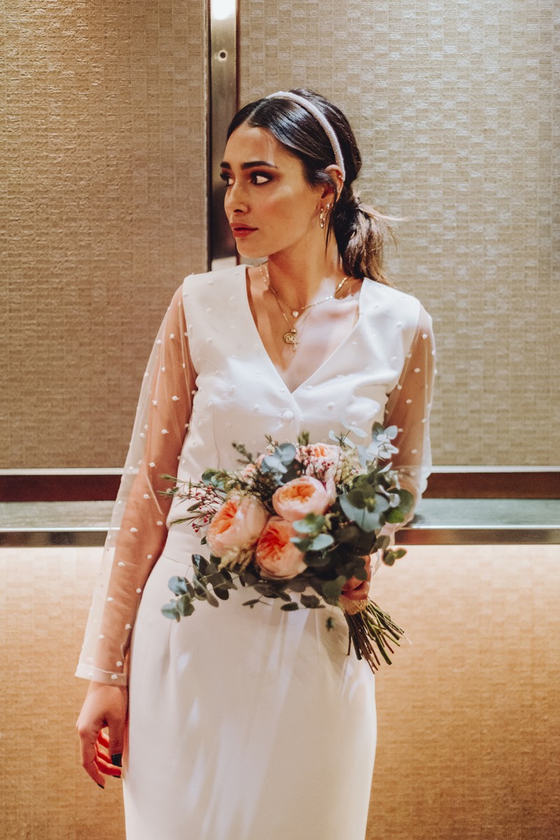 conjunto de falda midi blanca con plumas y blusa de plumetti manga larga con escote en pico para boda de dia