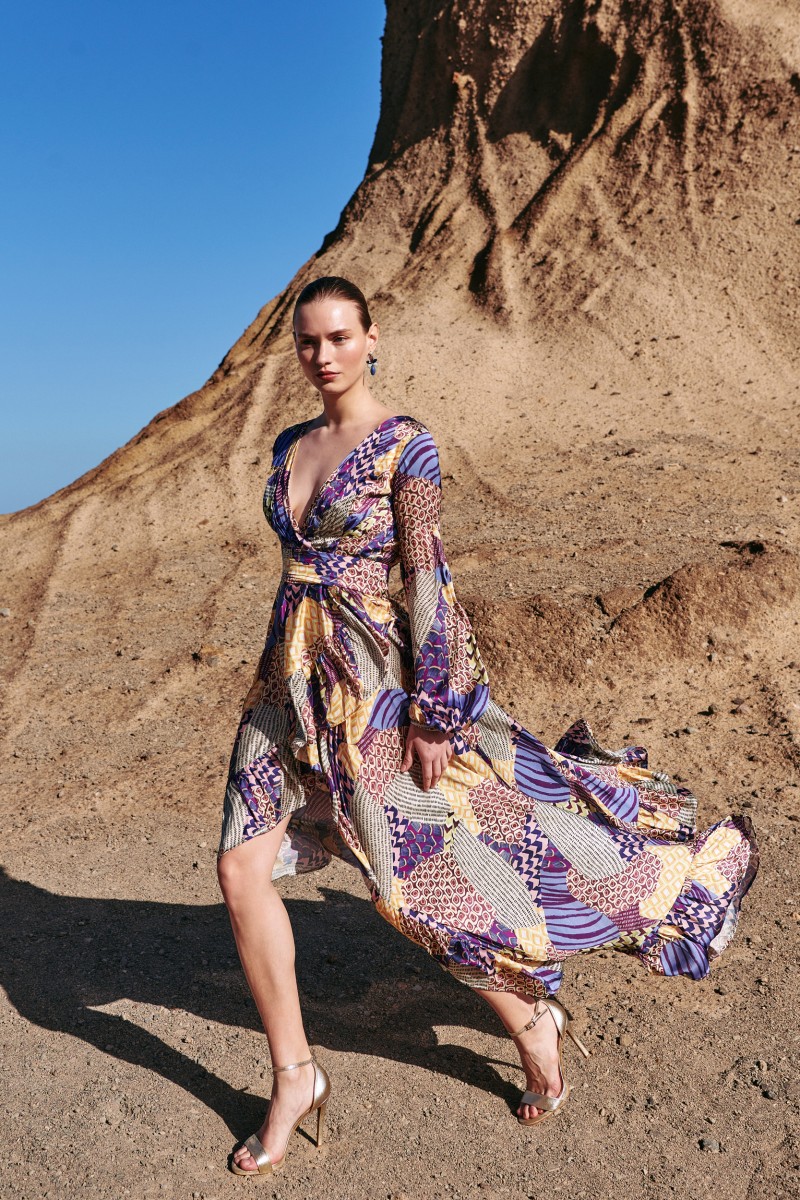 vestido largo cruzado con falda con volantes asimetrica en satén estampado geométrico en tonos lilas, morados, verdes y amarillos para invitadas a boda de noche