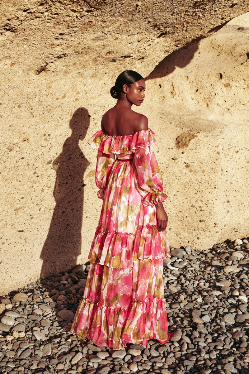 espectacular vestido largo confeccionado en un tejido de gasa de gran calidad estampada con delicadas flores en tonos rojos y rosas