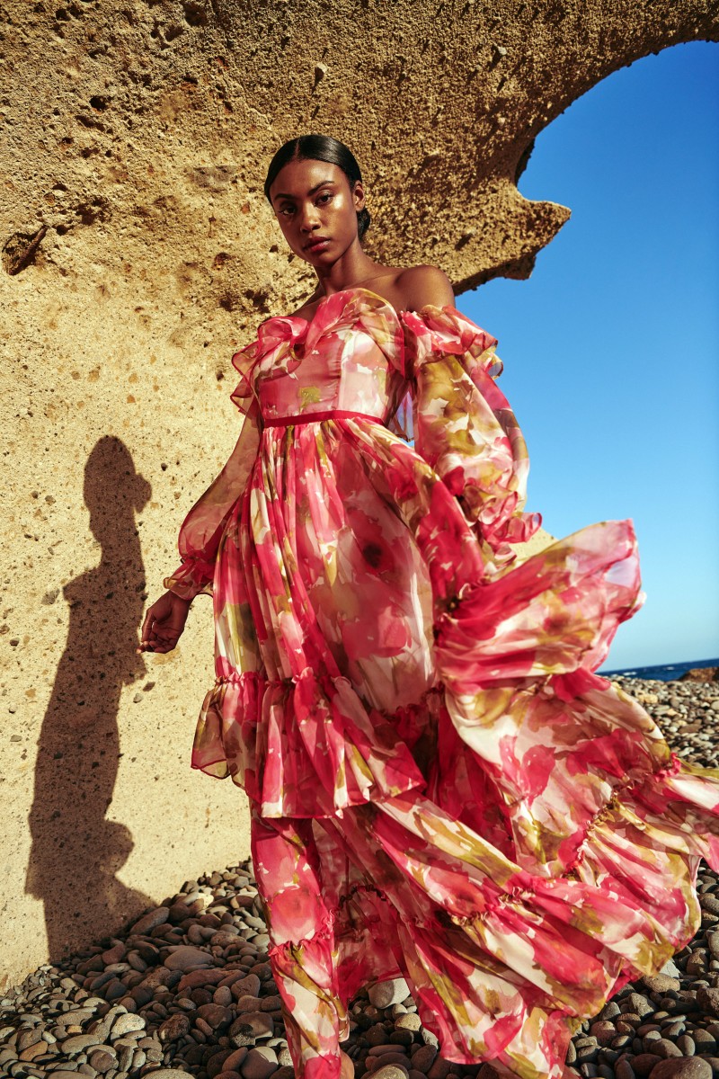 Maravilloso vestido largo confeccionado en un tejido de gasa de gran calidad estampada con delicadas flores en tonos rojos y rosas para boda